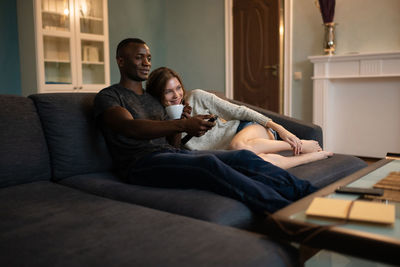 Happy friends sitting on sofa