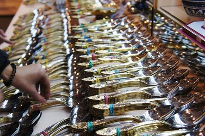 Cropped hand of woman buying spoon at shop