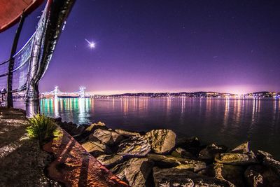 View of illuminated city at riverbank