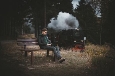 Man sitting on bench in park