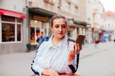 Portrait of young woman using mobile phone