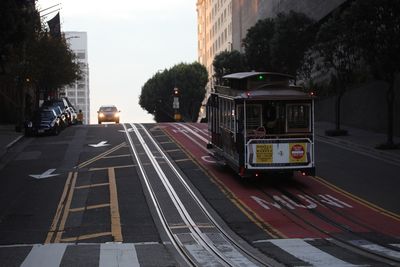 View of railroad tracks by street in city