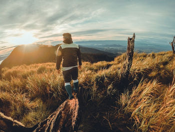 Rear view of man standing on land against sky