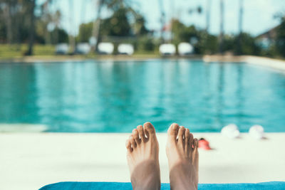 Feet of a woman relaxing at swimming pool