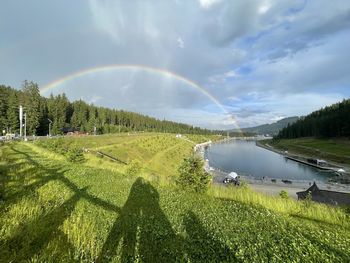Scenic view of rainbow over land against sky