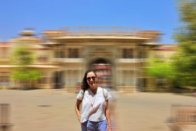 Portrait of smiling woman standing against blurred motion