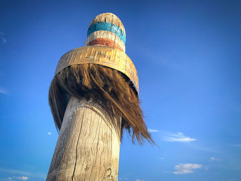 Low angle view of old wooden post against sky