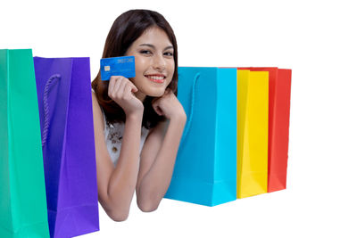 Portrait of young woman holding paper over white background