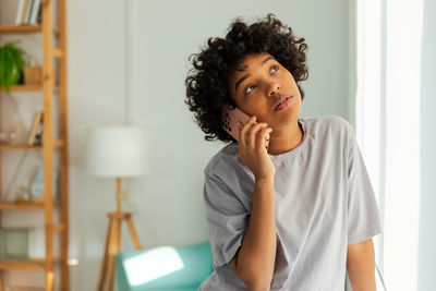 Portrait of young woman sitting on sofa at home