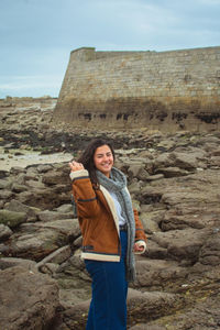 Portrait of smiling young woman standing on rock