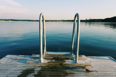 Pier by lake against sky