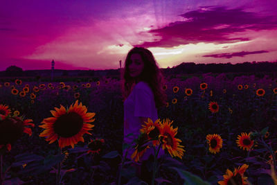 Rear view of person standing on field against sky during sunset