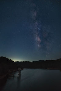 Scenic view of lake against sky at night