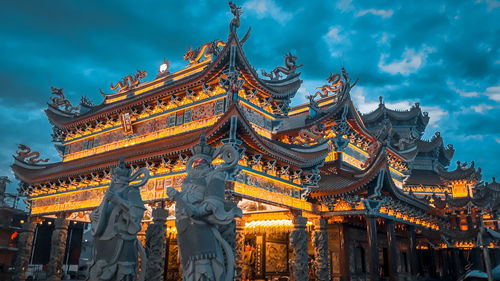 Low angle view of temple and building against sky