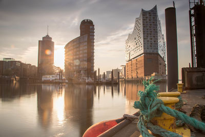 View of buildings at waterfront against cloudy sky