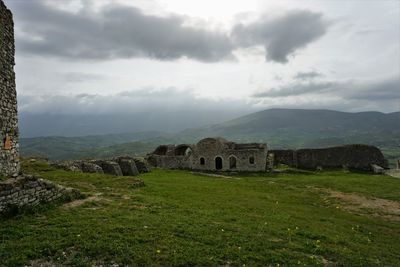 Old ruin on field against sky