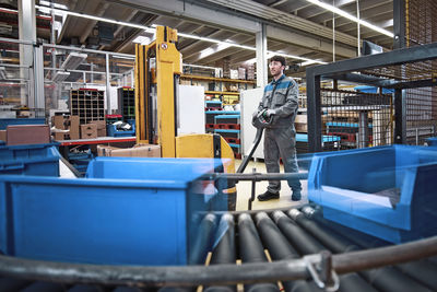 Man at work in factory with boxes on conveyor belt