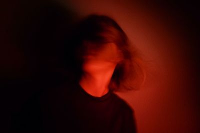 Portrait of a young woman over black background