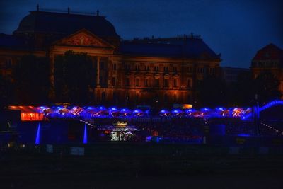 Illuminated city against sky at night