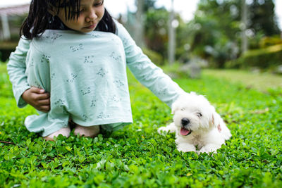 Portrait of young woman with dog on field