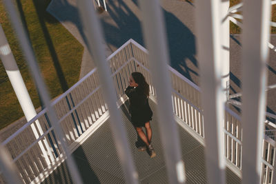 Young woman standing by railing of building