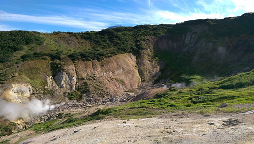 Scenic view of land and mountains against sky