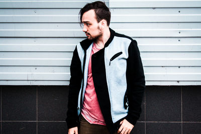 Young man standing against wall