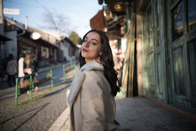 Portrait of young woman standing outdoors