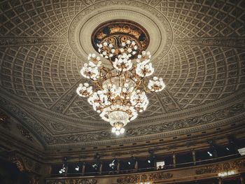 Low angle view of illuminated chandelier hanging from ceiling