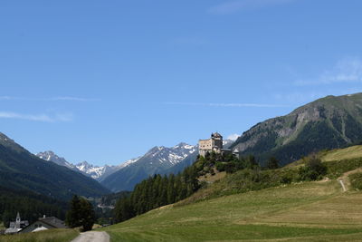 Scenic view of landscape and mountains against blue sky