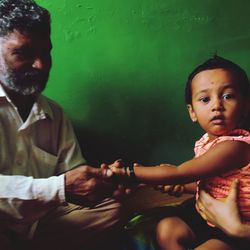 Grandfather with granddaughter sitting at home