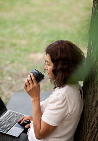 Side view of woman using mobile phone