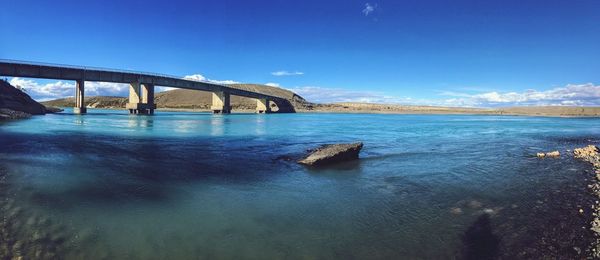 Bridge over river against blue sky