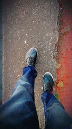 Low section of man standing on road