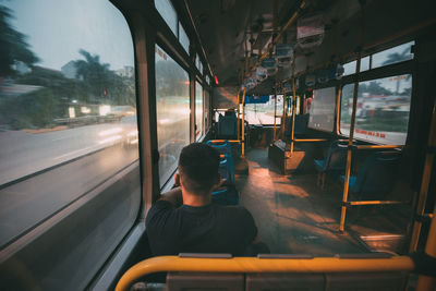 Rear view of man sitting in train
