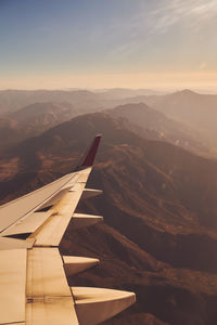 Scenic view of mountains against sky during sunset out of plane window