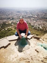 High angle view portrait of man crouching on rock formation