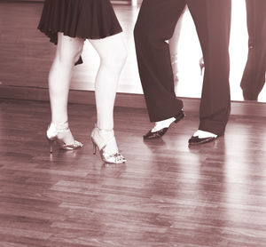 Low section of people dancing on hardwood floor at studio