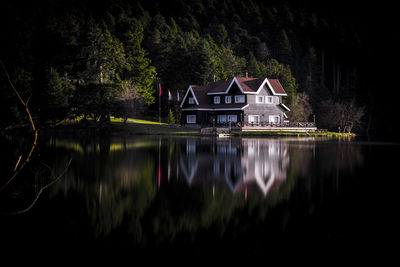 Reflection of trees and buildings in lake at night