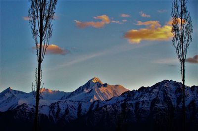 Scenic view of snowcapped mountains against sky during sunset