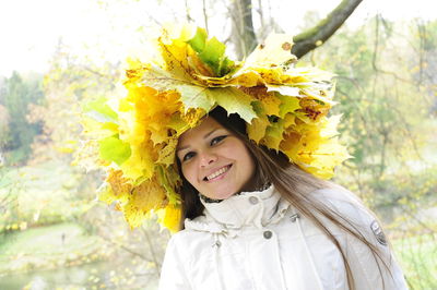 Portrait of smiling young woman with yellow flowers