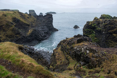 Rock formations on sea shore against sky