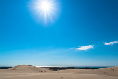 Scenic view of desert against blue sky