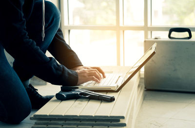 Man using mobile phone while sitting on table