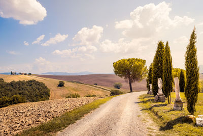 Dirt road along landscape and against sky