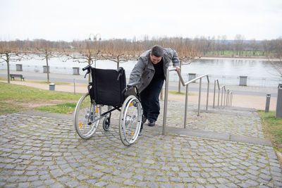 A physically disabled person in a wheelchair trying to go down the stairs