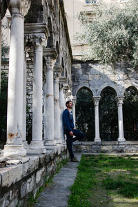 Full length portrait of man standing at historical building