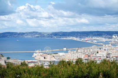 High angle view of city by sea against sky