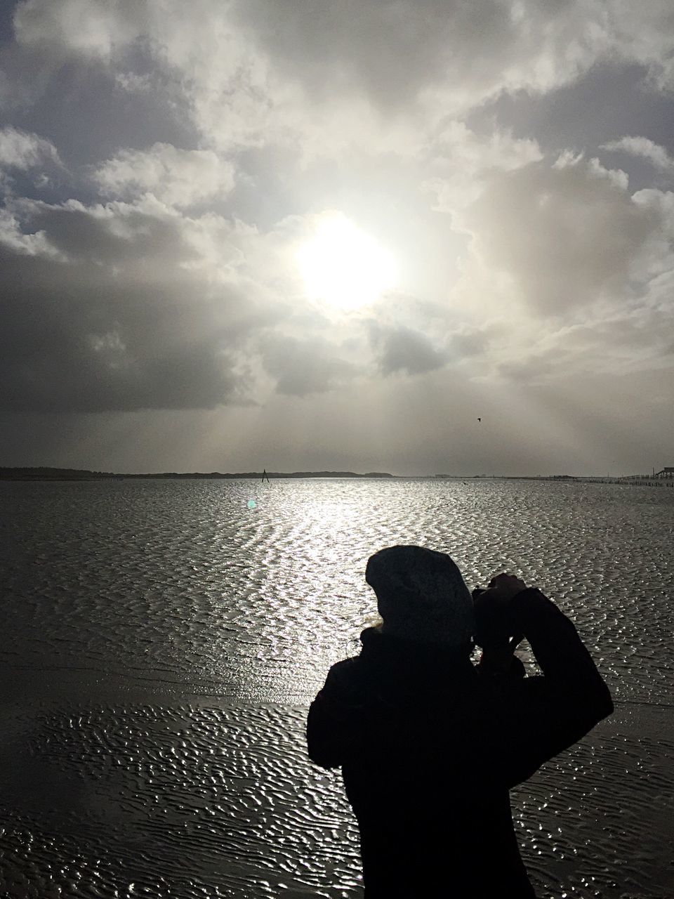 silhouette, one person, sunlight, one man only, cloud - sky, sky, people, rear view, sea, only men, real people, sunbeam, tranquility, men, adults only, adult, water, day, nature, outdoors, human body part