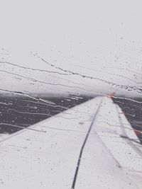 Close-up of wet airplane flying over road